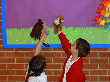 photo showing two children from Longscroft playing with puppets