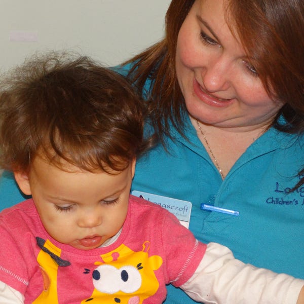 Photo of a baby with keyworker at Longscroft Nursery