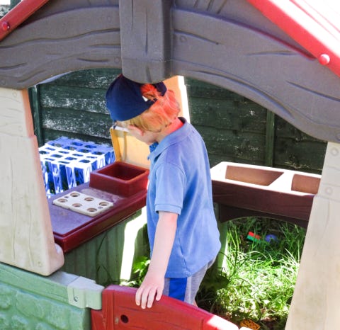 Photograph of a boy playing outdoors at Longscroft Nursery