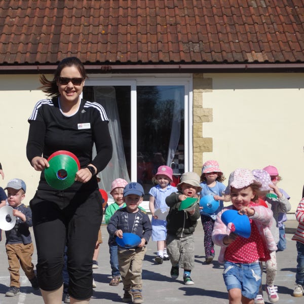 Photo of children running in playground at Longscroft Nursery with sports coach